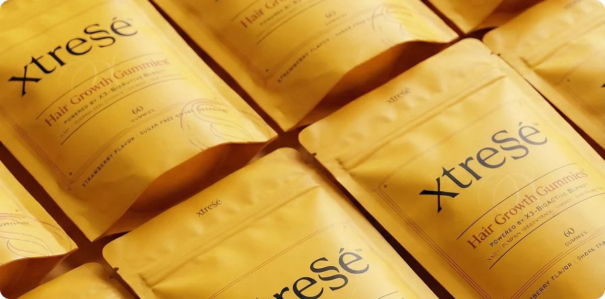 xtreèé hair growth gummies packaging on a brown background