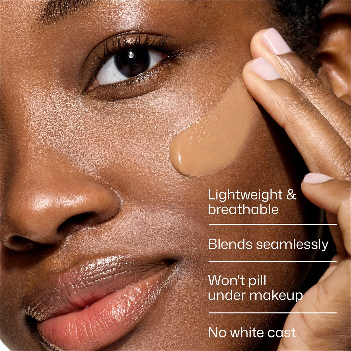 Close-up of a model applying liquid foundation to their cheek, with text overlays highlighting product benefits: 'Lightweight & breathable', 'Blends seamlessly', 'Won't pill under makeup', and 'No white cast'.